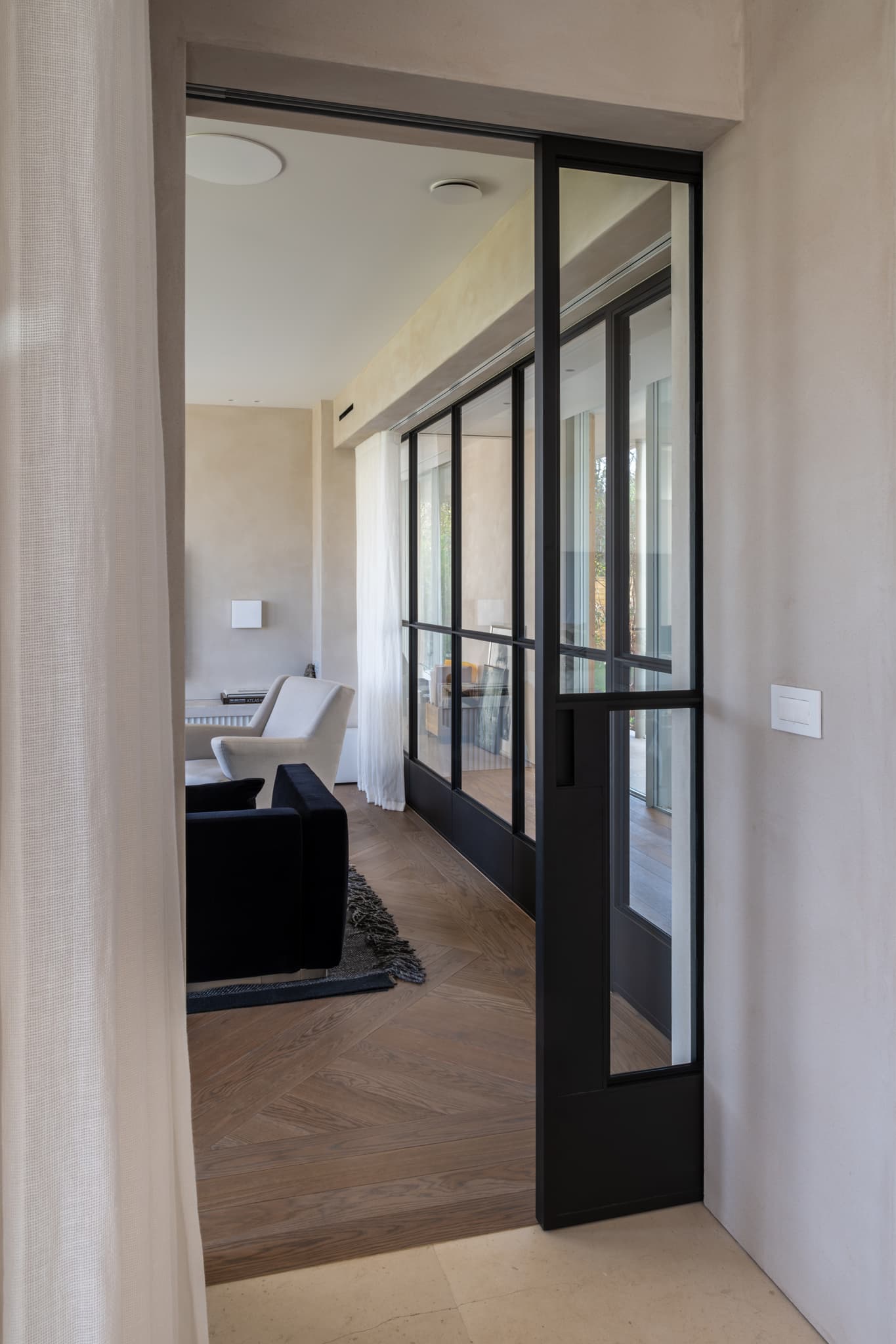 Acacia steel glazed sliding pocket door in a black finish seen in a modern luxury interior